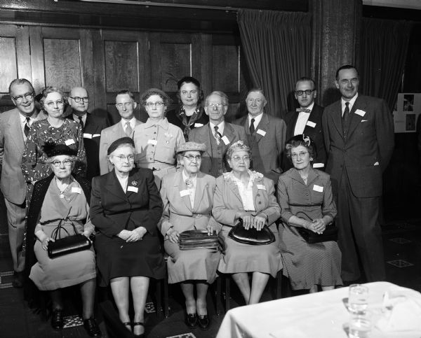 Group portrait of the <i>Wisconsin State Journal</i> staff with correspondents who were recognized for at least 20 years of service at the <i>Wisconsin State Journal's</i> correspondent's conference in Madison. Seated, left to right, are: Mrs. Arthur Paulson, Oregon; Mrs. Frank Doudna, Poynette; Mrs. William Hammermeister, Rock Springs; and Mrs. Robert Wallace, Cottage Grove. Standing, left to right, are: Joseph "Roundy" Coughlin, sports columnist; Mrs. Earl Gest, DeForest; Lawrence H. Fitzpatrick, city editor; Harold E. (Mac) McClelland, state editor; Mrs. A.W. Pickering, Black Earth; Louise Marston, society editor; Frank Doudna, Poynette; David Morgan, Mineral Point; Roy L. Matson, editor; and Don Anderson, publisher.