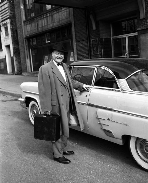 Henry J. McCormick, <i>Wisconsin State Journal<i> Sports Editor, stands beside an automobile before his departure for Bradenton, Florida to report on the Milwaukee Braves in spring training.