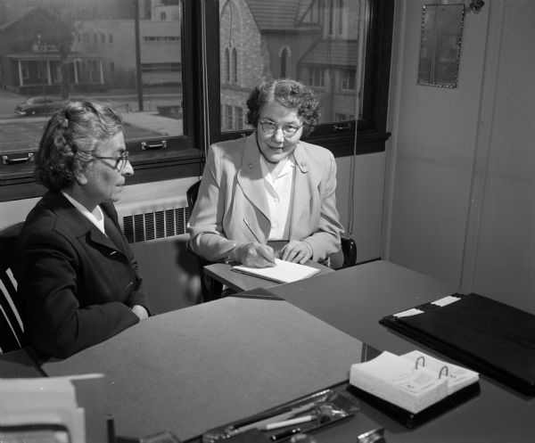 Sophie Siebecker, Executive Secretary of Family Service, dictates a letter to her secretary Mae Dieden. Dieden received her position through the Women's Service Exchange.
