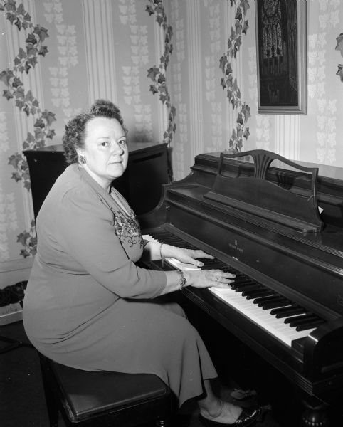 Portrait of Marion Hoesly seated at a piano. She and her daughter Luan Hoesly, who played an electric organ, performed duets for a weekly radio broadcast on WIBA and WIBA-FM. For more than five years they recorded their show in their living room. The recordings were broadcast as their weekly radio show.