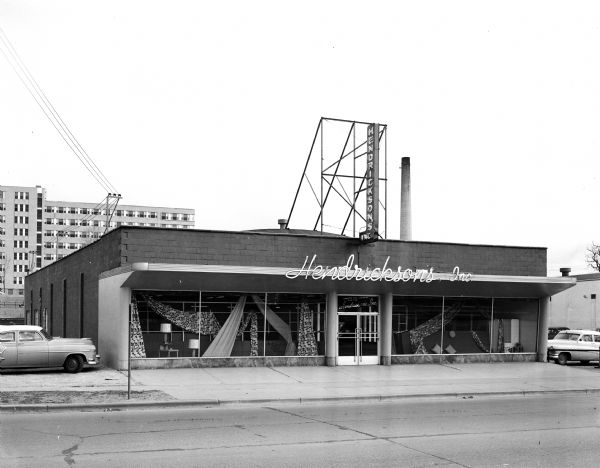Exterior view of Hendrickson's Modern Home Furnishing Store at 2570 University Avenue, taken for the store's grand opening. The VA hospital is in the background.