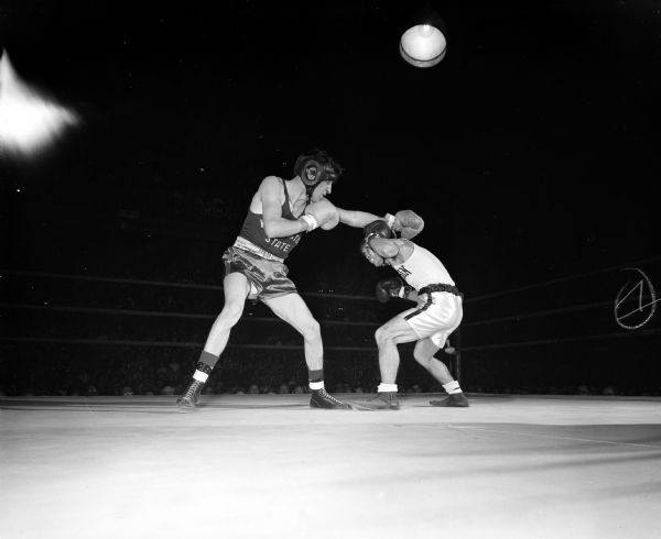Action shot showing University of Wisconsin Badger Roy Kuboyama ducking a punch delivered by Washington State Cougar, Eddie Olson. They boxed in the 125-pound division.