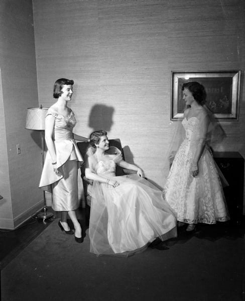 Three Delta Gamma sorority members model formal long dresses in preparation for the alumnae group's annual bridge party and style show. From left, they are Diana Dean, Nancy Herrick, and Virginia Bowman.