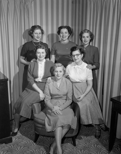 Group portrait of the Purim Ball committee of the B'nai B'rith Women's chapter. In the front row, left to right, are: Sally (Mrs. Robert) Roth, Mrs. Simon Delinky, and Selma (Mrs. William) Becker. Behind them are: Elizabeth (Mrs. Julius) Jacobs, Roslyn (Mrs. Ben) Kopelberg, and Sadye (Mrs. Harry) Schackter. Absent when the picture was taken were Bertha (Mrs. Jack) Schvid and Ann (Mrs. Sander) Gusinow.