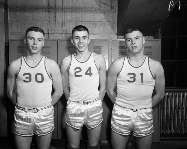 Group portrait of Bob Berquist, #30, St. Croix Falls High School basketball player and one of the team's ace scorers, with 2 other teammates.