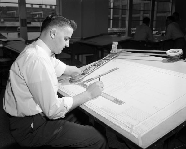 Portrait of Donald Fornasiere sitting at his drafting table in the special tools engineering department at Gisholt Machine Company. Mr. Fornasiere is part of the 'Madison Story' — the account of the opportunities this city offers its handicapped men and women who want a chance to work and enjoy the lives of self-supporting citizens.