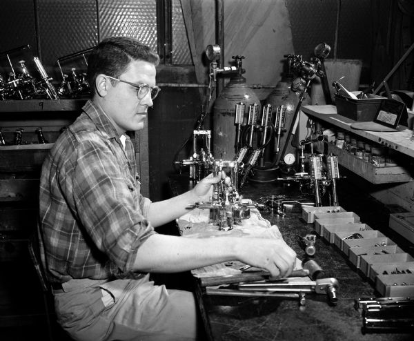 Portrait of Howard Davis at his job as a general assembler at the Ohio Chemical and Surgical Equipment Company. Mr. Davis is part of the 'Madison Story' — the account of the opportunities this city offers its handicapped men and women who want a chance to work and enjoy the lives of self-supporting citizens.