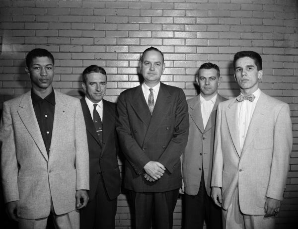 Group portrait of 5 attendees at the Madison Central High School athletic banquet. Pictured, left to right, are Bill Gothard, school athlete; Harold Pollock, football coach; Gil McDonald, UW basketball official; Robert Alwin, basketball coach; and Rollo Vallem, school athlete.