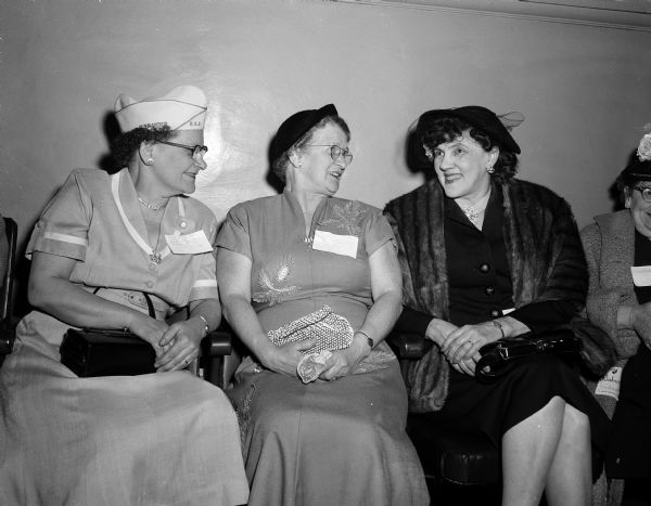 Three members of the Ladies auxiliary sitting together while talking. They are Leatha Fuller, a department commander of the auxiliary, Mrs. Herb Pommerening of Oshkosh, and Mrs. Judith Johnson.