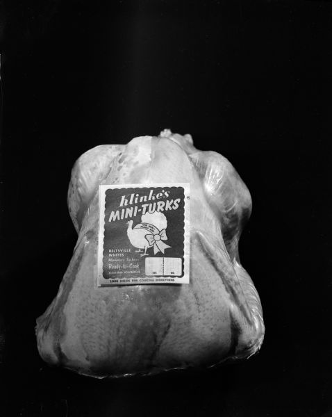 Dressed turkey with label reading, "Klinke's Mini-Turks; Beltsville Whites; Miniature Turkeys, Ready to Cook, Madison Wis. One meal, Family size, Look inside for cooking instructions."