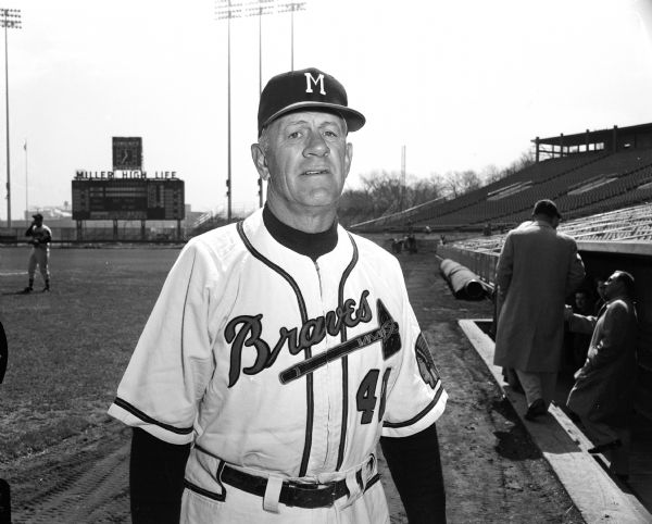 Portrait of Milwaukee Braves manager Charlie Grimm in front of the dugout at County Stadium.
