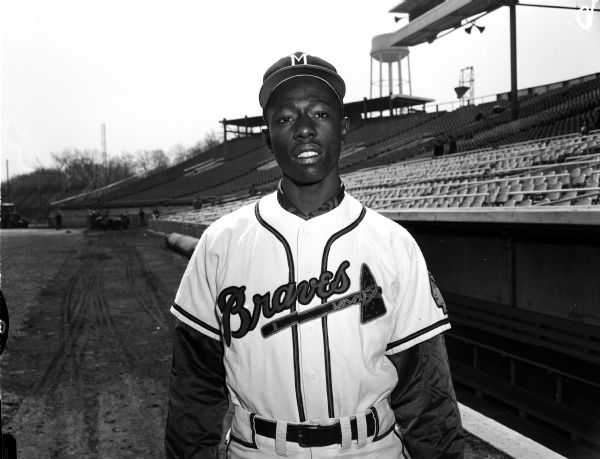 Portrait of Hall of fame Milwaukee Braves outfielder Henry Aaron in front of the dugout at County Stadium.