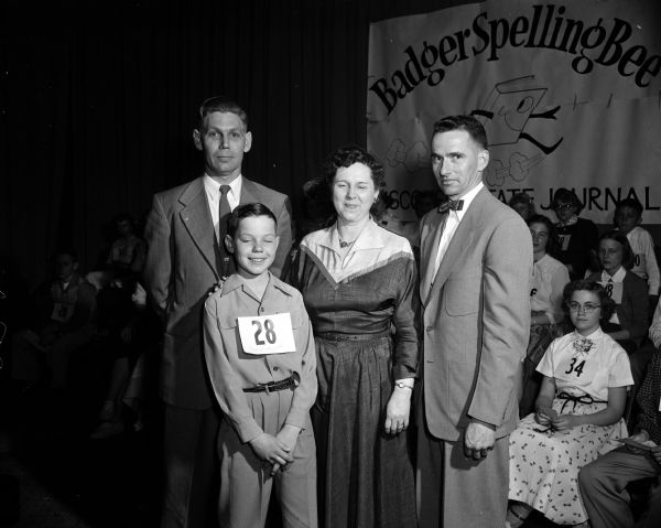 Badger Spelling Bee champion Robert Suszycki of Mauston posing with his father and mother, Mr. and Mrs. Norman Suszycki, and his teacher Howard Mackin.