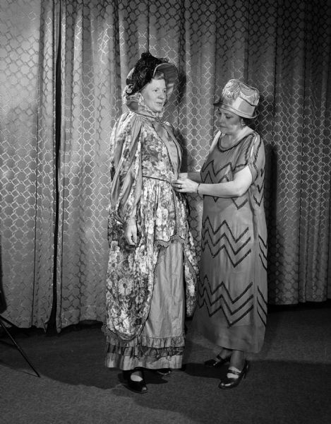 One of a series of scenes from the dramatic production "Down Memory Lane", presented in celebration of the 60th anniversary of the founding of the Madison Woman's Club. Mrs. D.J. Benedict, left, wears a costume from the 1890's and Emma Hooper wears a dress and hat from the 1920's.