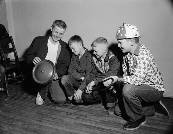 Two former soap box derby champions talk with two boys planning to enter the race. Pictured are (left to right): Pierre Slightam, Madison's 1949 champion; Gary Lovelace; Roger Wood; and Larry Jacobson, the 1953 champion.