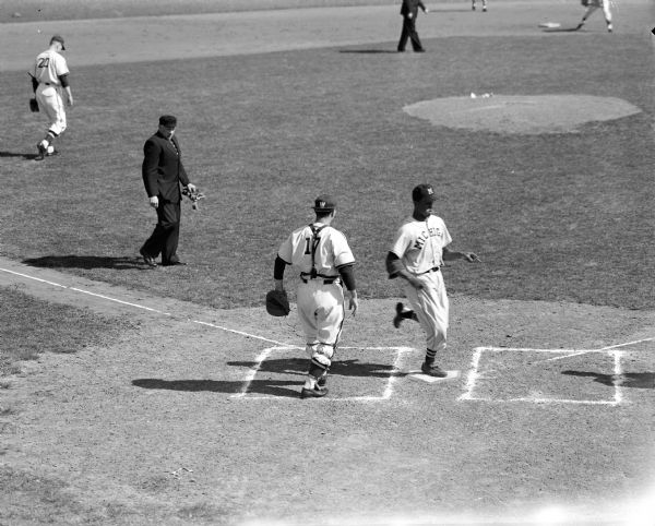 Elevated view of Don Eaddy, Michigan third baseman, scoring the only run of the game at Lowman Field during a Wisconsin vs. Michigan baseball game.
