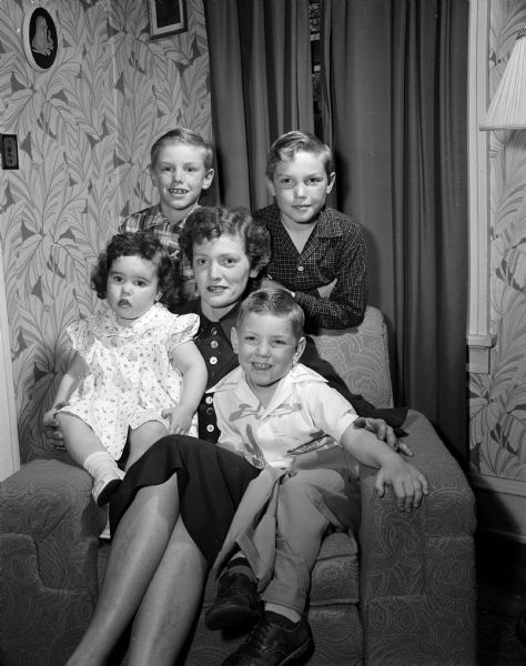 Group portrait of Mary Dushan surrounded by her four children. They are, clockwise from upper left: Andy, 7, Joseph Jr., 9 1/2, Jimmy, 4, and Patrica Ann, 2. The Dushan family were leaving Truax apartments before sailing to Wethersfield, England to join their father and husband, Warrant Officer Joseph Dushan.