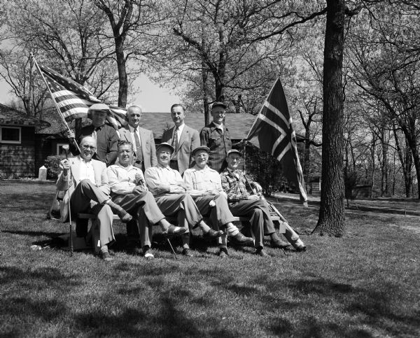 Group portrait of the Norwegian Svttende Mai-Turnering golfers at the Blackhawk Country club with Norwegian and American flags. Seated from left: Henry L. Bakken, Lester C. Lee, Herman Loftsgordon, Oscar Christianson and Albert S. Lerdahl. Standing from left: Basil Peterson, E.R. Gestland, Nels Lerdahl and Art Lowe.