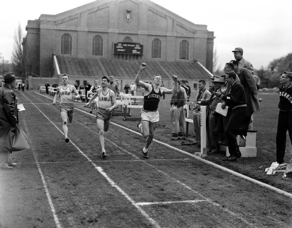 Jackie Mansfield crosses the finish line and wins the 440-yard dash at Camp Randall as part of the University of Wisconsin vs. Iowa Track Meet.