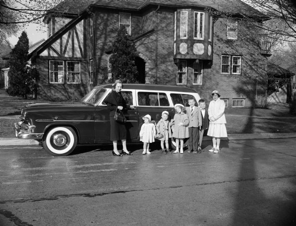 Alzada McCormick and her six children standing next to the family station wagon. The children are, from left: Mary, age 2, James, 3, Patricia, 5, Riley, 7, Timothy, 9, and Colleen, 11. The photograph was taken as part of a Mother's Day article featuring the many roles performed by stay-at-home mothers.