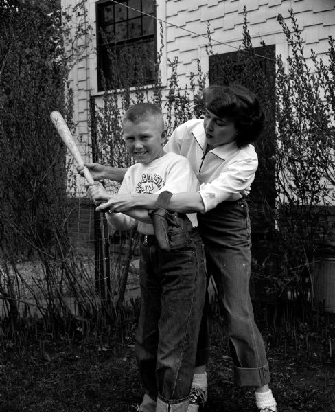 Dorothy Lutey shows her son Craig, age 9, how to swing a baseball bat. The photograph was taken for a Mother's Day article featuring the many roles performed by stay-at-home mothers.