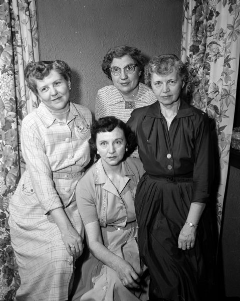 Group portrait of the officers of the Madison deanery of the Madison Diocesan council of the National Council of Catholic Women. Seated is Mrs. Loren Griswold, president. Standing, left to right, are: Mrs. Lyle (Mildred) Minto, recording secretary; Mrs. John L. (Sophia) Nichols, corresponding secretary; and Mrs. John P. (Ruth) Rocca, treasurer.