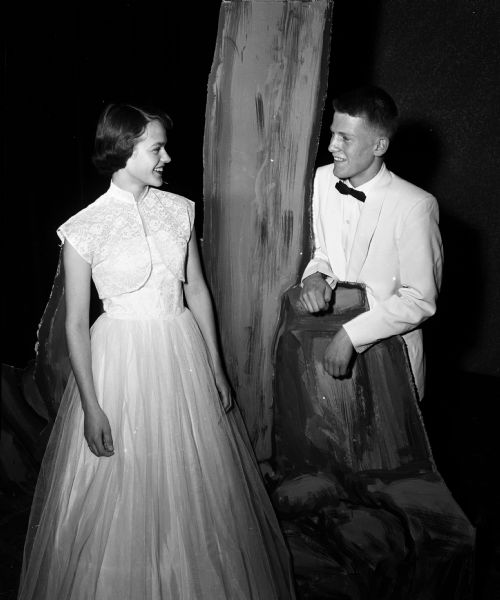 Prom Queen and King Geraldine Ball and David Coster posing for a portrait beside a tree and rock props while in formal attire.