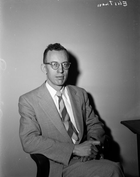 Portrait of Mr. Ekstrom seated in a chair.
