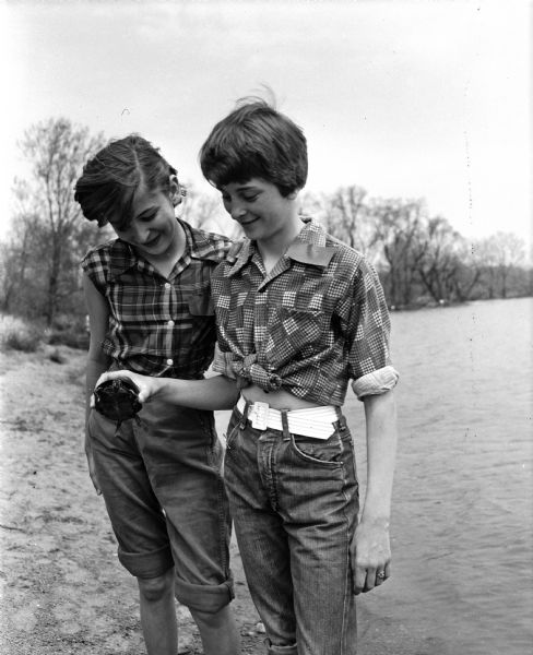 Two campers from Sun Prairie looking at a turtle found during the seventh and eighth grade Girl Scouts play day at the Black Hawk Council's Camp Brandenburg. They are Jean Bohlang (left) and Mary Ann Hauge.