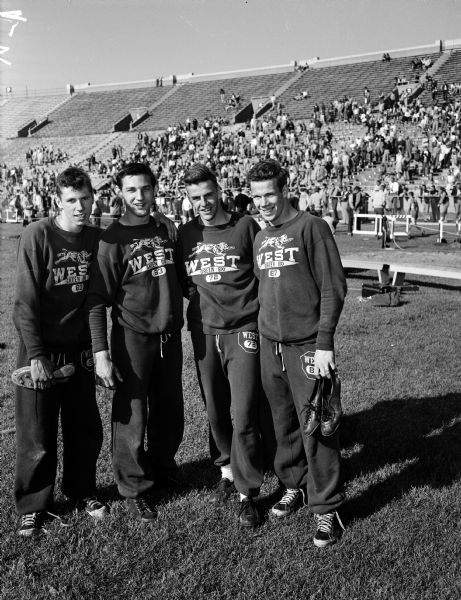 Group portrait of the Green Bay West 880-yard relay team that set a new state record at the state high school track meet at Camp Randall Stadium. From left are Fran Wolfe, Wayne Zimmerman, Ken Joachim, and Bill Andersen.