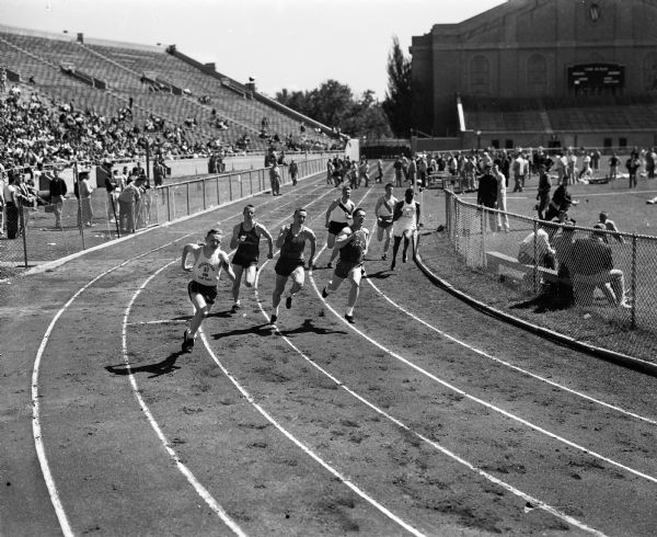 Action shot of runners in one section of the Class A quarter-mile race at the state high school track meet at Camp Randall Stadium. The winner of this section and the event was Jesse Nixon of Milwaukee Lincoln, at far right.
