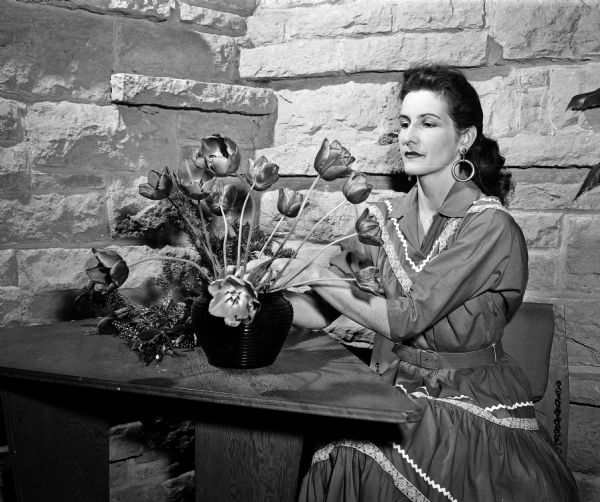 Mrs. Robert L. Sakrison, chairman of publicity for the Federated Garden Clubs flower show, arranging a bouquet of tulips.