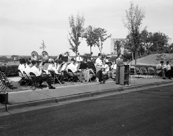 Jerry Host, former state American Legion commander, gives the address during Flag Day ceremonies at the Madison Veterans Administration Hospital with the Madison Zor Shrine band in the background.
