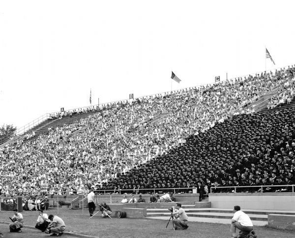One of three negatives that make a panorama of University of Wisconsin graduates and families sitting in the stands at Camp Randall Stadium during graduation ceremonies.
