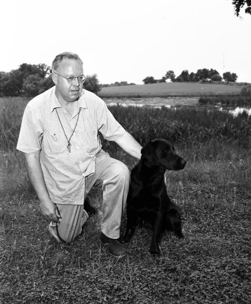 Portrait of Ken Williams of Milwaukee  with his dog, Nilo's Possibility. The dog was a champion in the Wisconsin Retriever field trials at Westport.