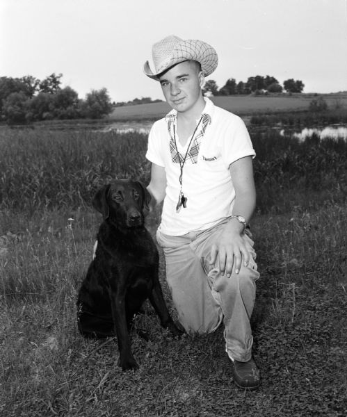 John Romadha Jr. of Waukesha is shown with his dog, Kingswere's Black Ebony. The dog was a champion in the Wisconsin Retriever field trials at Westport.