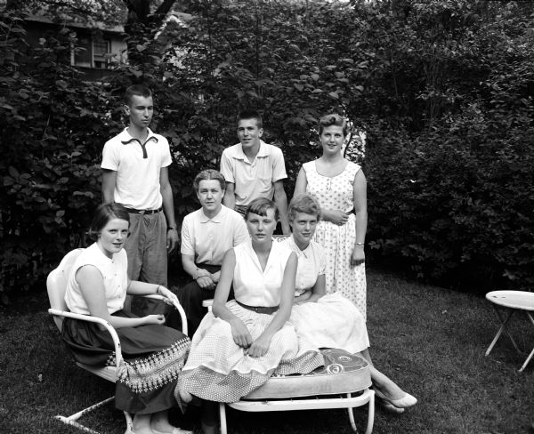 Group portrait of some of the young people assisting with arrangements for a high school dance to be held at the Maple Bluff Country Club. Seated, left to right, are: Sally Canfield, advisor Mrs. Randolph R. (Anne) Conners, Jane Schlotthauer, and Lynn Nickles. Standing, left to right, are: John Icke, Byron Johnson, and Trudi Kubly.