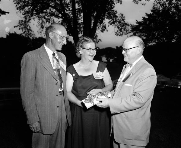 Alumni socialize at the East High Class Reunion held at Maple Bluff Country Club. Shown left to right are: Willis Hart from Poynette, Wisconsin, class of 1925, who received an award for having the most grandchildren of all the attendees; Mrs. Norman Harloff, the former Janet Riley, from Colorado Springs, Colorado, who received a prize for coming the greatest distance; and Frederick W. Le Febrve residing at 801 Lewis Court in Madison, also class of 1925, who had the honor of handing out the awards.