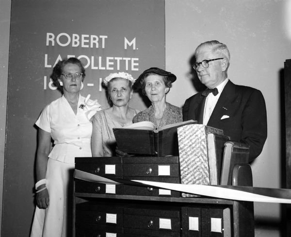 Four relatives of Senator Robert M. "Fighting Bob" La Follette look over the collection of his personal papers which were presented and opened at the Wisconsin Historical Society. Shown left to right are: daughter-in-law Isabel La Follette, wife of Philip F. La Follette; daughter-in-law Rachel La Follette; widow of Robert M. La Follette Jr.; daughter Fola La Follette; and son Phillip F. La Follette, Ex-Governor of Wisconsin.
