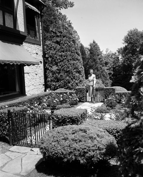 Vera Ford standing in her formal garden at her residence at 500 Farwell Drive in Maple Bluff. The garden is included in the Attic Angel Garden Tour, an annual event to raise funds for the Attic Angel Nursing Home located at 102 East Gorham Street.