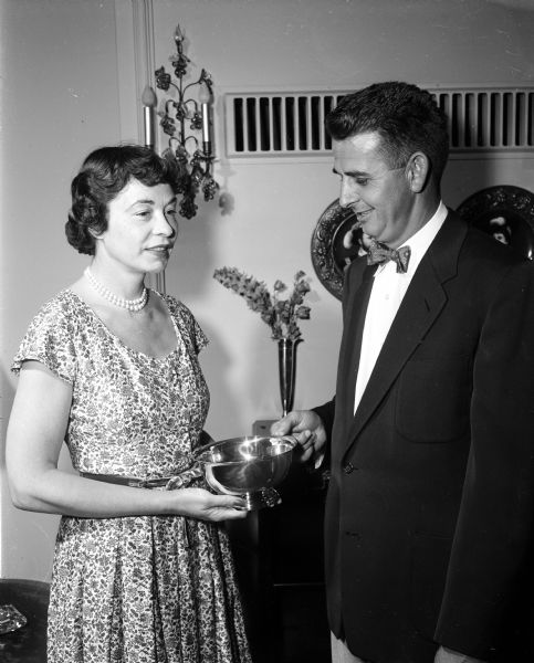 Mrs. Walter J. (Charlotte) Kohler presents a sterling silver bowl donated by she and her husband to William E. Marshner, president of the Badger Kennel Club. The bowl will be awarded to the best dog in show at the annual All-Breed and Obedience Dog Show.