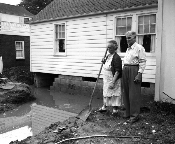 Mr. and Mrs. Willard Burbank look at the flooded basement of their home at 829 Burbank Place in the Garden Homes subdivision of Madison.
