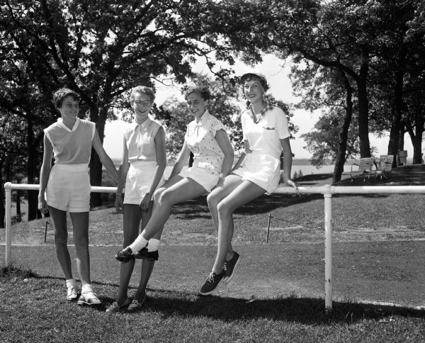 Perched on Number 1 tee awaiting the assignment of their duties are four of the teenage girls who will serve as pages at the 42nd annual state tournament of the Wisconsin Women's Golf Association at the Blackhawk County Club. The girls, all daughters of club members, are Betty Blue, Barbara Dettloff, Mary Beckwith and Sharon Bleecker. During the tournament the girls will be seen in white shorts, as they carry messages, run errands, and serve as general helpers.