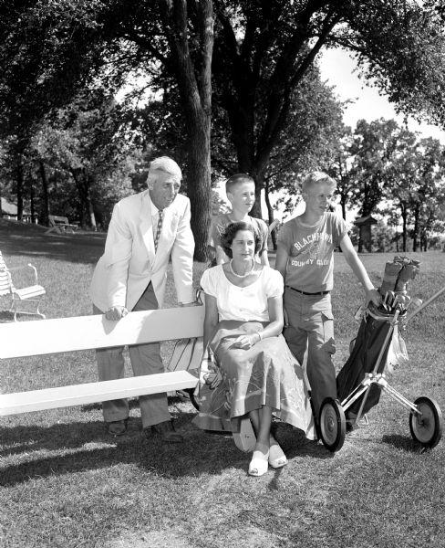Karl Schlicht, Blackhawk Country Club professional, and caddy chairman Charline Larson are pictured with two twin caddies, David Pearson and Dennis Pearson, 15 years old. "Kully" Schlicht is responsible for training the caddies and he will serve as official starter for the 42nd annual state tournament of the Wisconsin Women's Golf Association at the Blackhawk County Club.