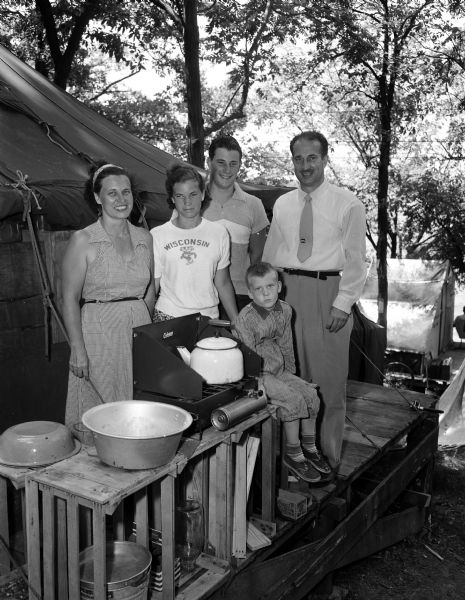 Professor J. Duke Elkow and his family stand at their "summer home" at the University of Wisconsin tent colony on Lake Mendota.