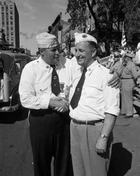Gordon Roseleip, left, congratulates James Marteneau of Oconto, his successor as the state commander of the American Legion, at the legion parade around the Capitol Square.