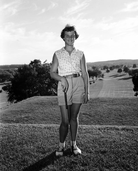 Portrait of Marilyn Hall of Milwaukee, before competing in a match with Carol Sorenson for the junior golf championship of the Wisconsin Women's Golf Association held at the Blackhawk Country Club. She was the eventual winner of the championship.