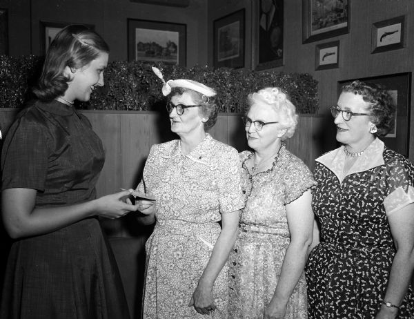 Marilyn Klettke of Oshkosh receives a scholarship from Mrs. Marguerite Townley, chairman of the service-civic committee of the Wisconsin chapter of the American Business Women's Association. Looking on are Marion Griffin and Leone Kellerman, members of the committee. Marilyn is a student nurse in the Madison General Hospital School of Nursing.