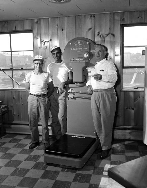 Floyd Klahn (left), Dale Ross, and B.L. Macken stand by a new electronic scale used to weigh Madison Soap Box Derby entries.