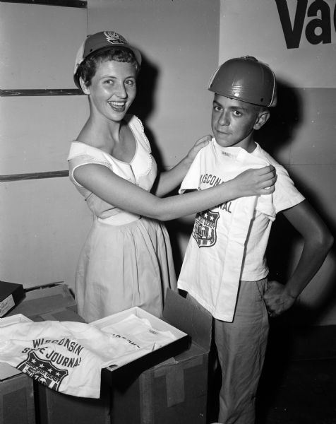 Lois Langeteig, assistant librarian at The Wisconsin State Journal, gives a tee shirt and helmet to David Laverty, 11, of Mineral Point, Wisconsin. Each boy participating in the Soap Box Derby was given these two items.

